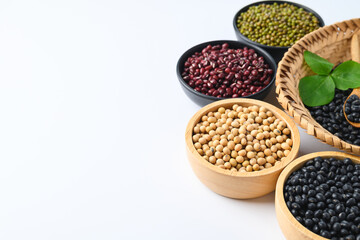 Various beans (black soybean, soybean, azuki bean and mung bean seeds) in a bowl on white background