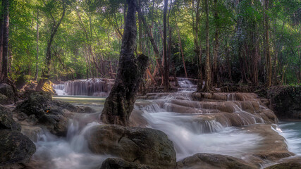 Obraz premium Erawan Waterfall at Kanchanaburi in Thailand. It has the perfection of forests of various species in nature. A lot of water flows down through the layers of limestone in rainy season.