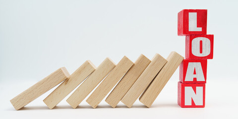 On a white background, wooden dice fell like dominoes, the fall was stopped by cubes with the inscription - LOAN