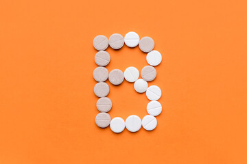 Vitamin B pills on color background