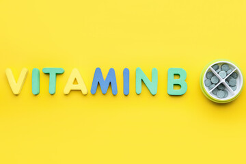 Text VITAMIN B with pills on color background