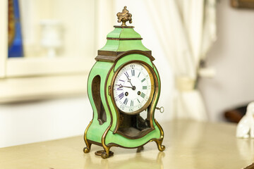 Close-up of an antique green clock on furniture