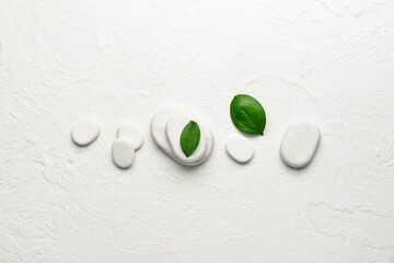 Spa stones with leaves on white background