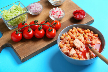Bowl with homemade pozole soup and ingredients on color background