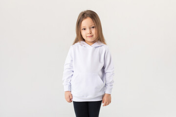 Cute baby girl in a white blank hoodie on a white background. Kids hoodies mockup.