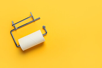Holder with empty toilet paper tube on orange background