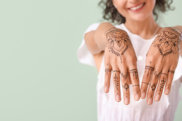 Beautiful Indian woman with henna tattoo on color background - Powered by Adobe