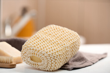 Bath sponge and towel on table in bathroom, closeup