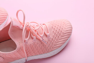 Sportive shoes on pink background, closeup