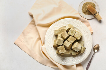 Plate with tasty hojicha marshmallows and chasen on light background