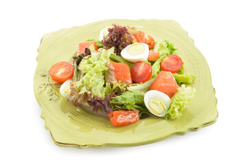 Delicious salad with salmon and fresh vegetables in plate on white background
