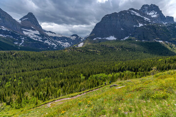 Spring Trail - A wide-angle Spring view of Iceberg Ptarmigan Trail winding along Swiftcurrent Valley, with Mt. Grinnell and Mt. Wilbur towering above.  Many Glacier, Glacier National Park, MT, USA.