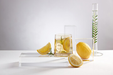 Lemon juice with sliced lemon transparent podium , petri dish in a white background , green leaf in...