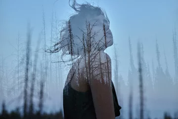Portrait of a girl with double exposure against a tree crown. Delicate mysterious portrait of a woman with a blue sky in wood © angel_nt