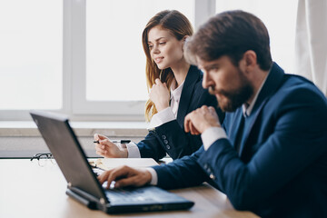 business man and woman sitting in front of a laptop teamwork internet officials