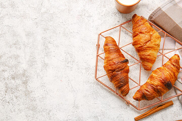 Grid with delicious croissants on light background