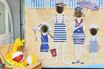 Tourist face hole board with family on beach