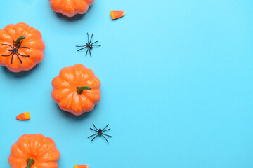 Pumpkins with spiders and candies on blue background