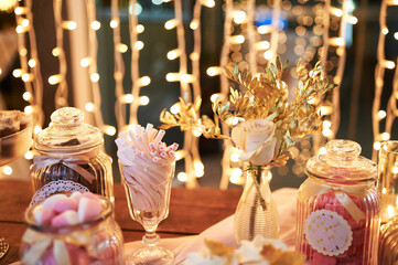 Various sweets and bouquet on table
