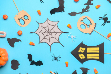 Halloween decor with tasty candies on blue background