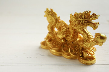 Figurine of Chinese dragon on white wooden background