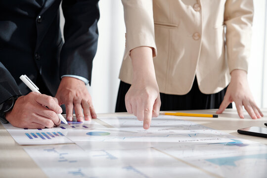 Managers of marketing department working on new strategy and analyzing data in various reports