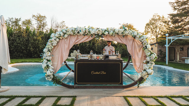 Young Caucasian Bartender At Work In A Cocktail Station Outdoors In A Location Venue In A Party At Sunset