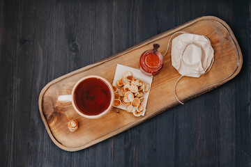 tea and jar with jam on a wooden tray