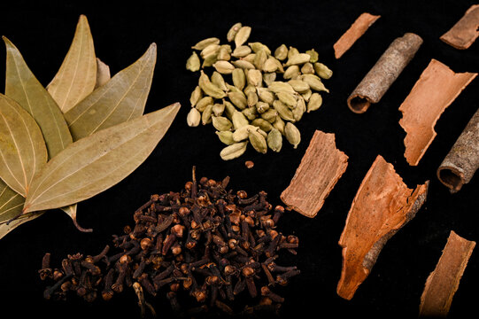Garam Masala  with ingredients, those are a common spice ,Garam masala in Indian kitchen.Cinnamon sticks , clove spices, Green Cardamom (Elaichi), Indian Bay Leaf, Cinnamomum Tamala. top view