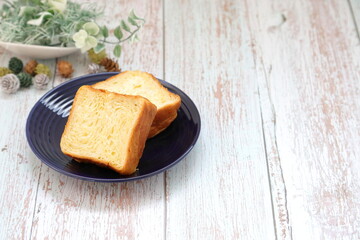 紺色のお皿に乗せたデニッシュと観葉植物｜右スペース