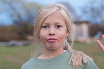 girl grimaces in front of the camera in nature