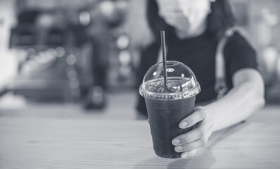 barista serving coffee frappe in plastic cup