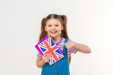 A schoolgirl points her finger at an English textbook. Study and translation of foreign languages.