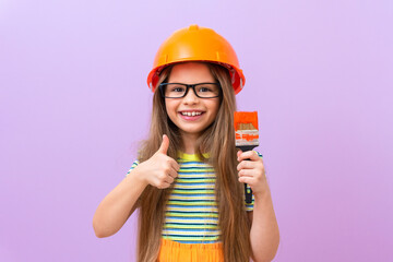 Renovation in the children's room. A little girl with a tassel and a protective helmet.