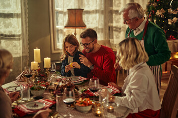 Cheerful family at dining table for christmas lunch in the house