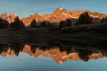 Fototapeta na wymiar Autumn sunrise with reflections on Scherbadung peak, Alpe Devero and Veglia natural park
