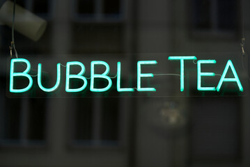 Light green neon text bubble tea at shopping window at downtown Zürich on a cloudy day. Photo taken October 12th, 2021, Zurich, Switzerland.