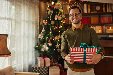 Smiling young man with Christmas gift