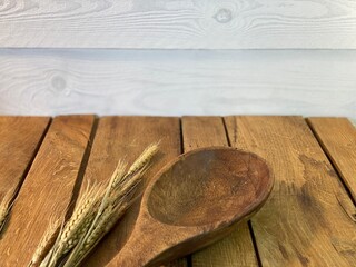 background made of oak planks and pine planks painted white on the table a bundle of corn and a wooden spoon