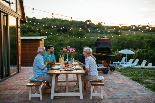 Affectionate Family Enjoying Dinner During Their Get Together In The Backyard