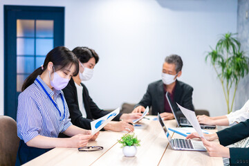 マスクをして会議をするビジネスパーソン