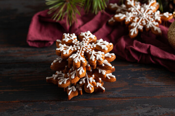 Christmas background with homemade snowflake shape gingerbread cookies on wooden background. New Year celebration traditions concept.
