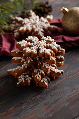 Christmas background with homemade snowflake shape gingerbread cookies on wooden background. New Year celebration traditions concept.