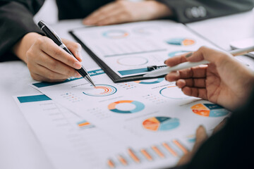 Close up of businesspeople discussing and analysis chart graph business report at the workplace, investor trading stock market, project planning, financial and investment concept.