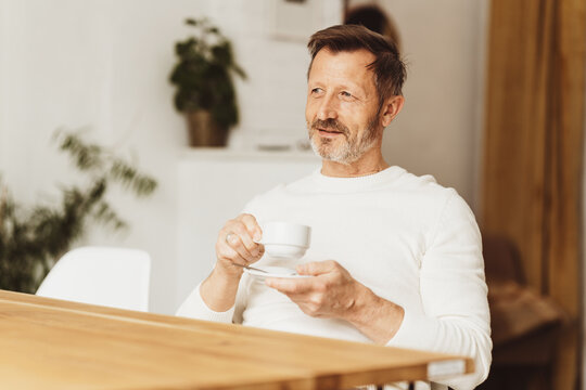 Pensive middle-aged man enjoying a cup of hot tea - Powered by Adobe