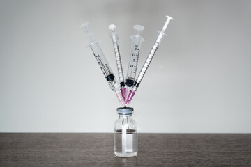 A vaccine vial with 4 syringes. A fourth dose Covid-19 vaccine booster shot concept.