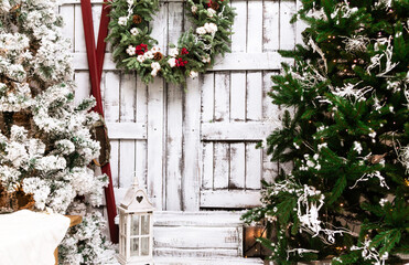 Fototapeta na wymiar Christmas decorated house and yard. Studio decoration in New Year style. Snow covered courtyard of a wooden house or cottage.