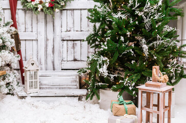 Christmas decorated house and yard. Studio decoration in New Year style. Snow covered courtyard of a wooden house or cottage.