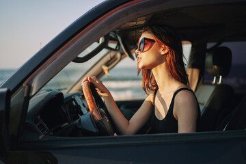 Plakat pretty woman in sunglasses driving a car trip