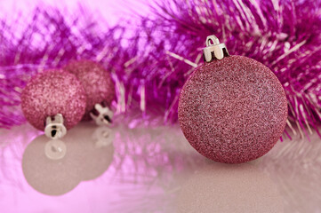 Christmas and New Year decorations. Pink Christmas tree balls and garland are on the table.